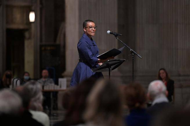 Adjoa Andoh, a black woman in a dark blue dress, reads from the lectern at St Paul's Cathedral