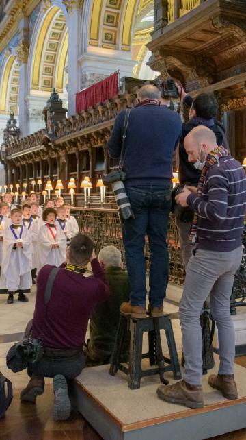 Press photographers take photos of the choristers during a media visit