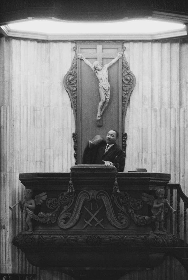 a black and white photograph of Dr Martin Luther King Jr preaching from the pulpit at St Paul's Cathedral