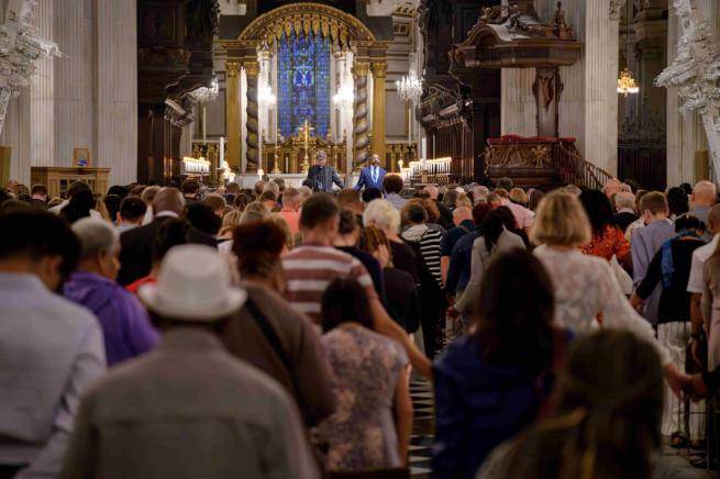 Revd Raphael Warnock and Dean Andrew Tremlett pray with a congregation during a learning event