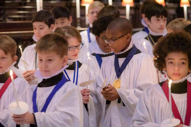 choristers boys sharing candle light christmas