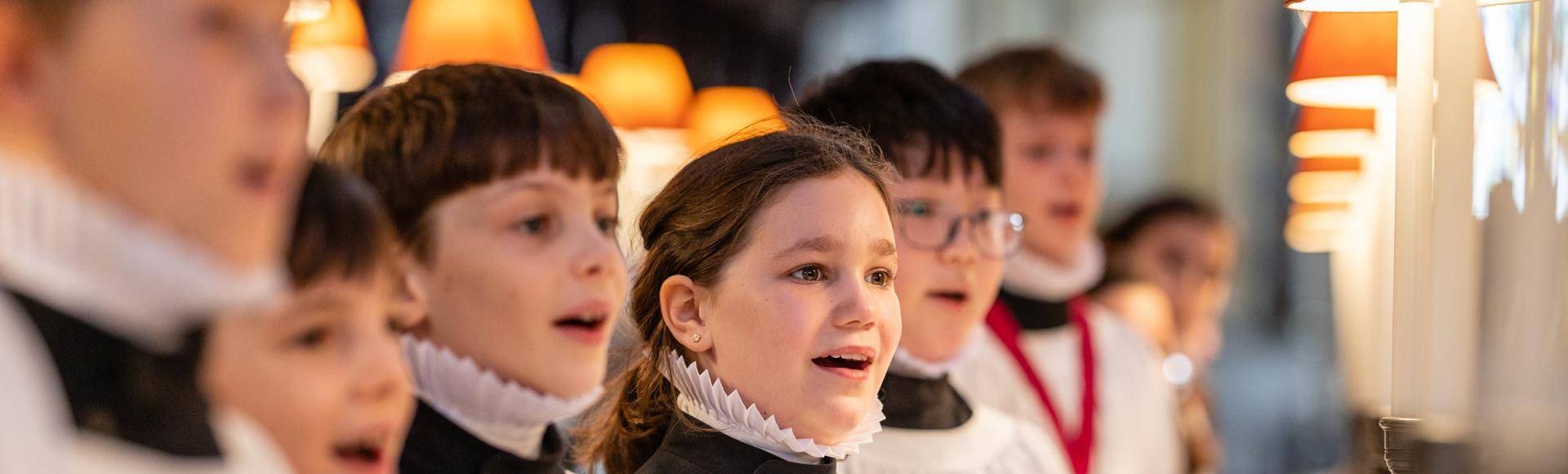 Girl and boy choristers in robes singing in the quire