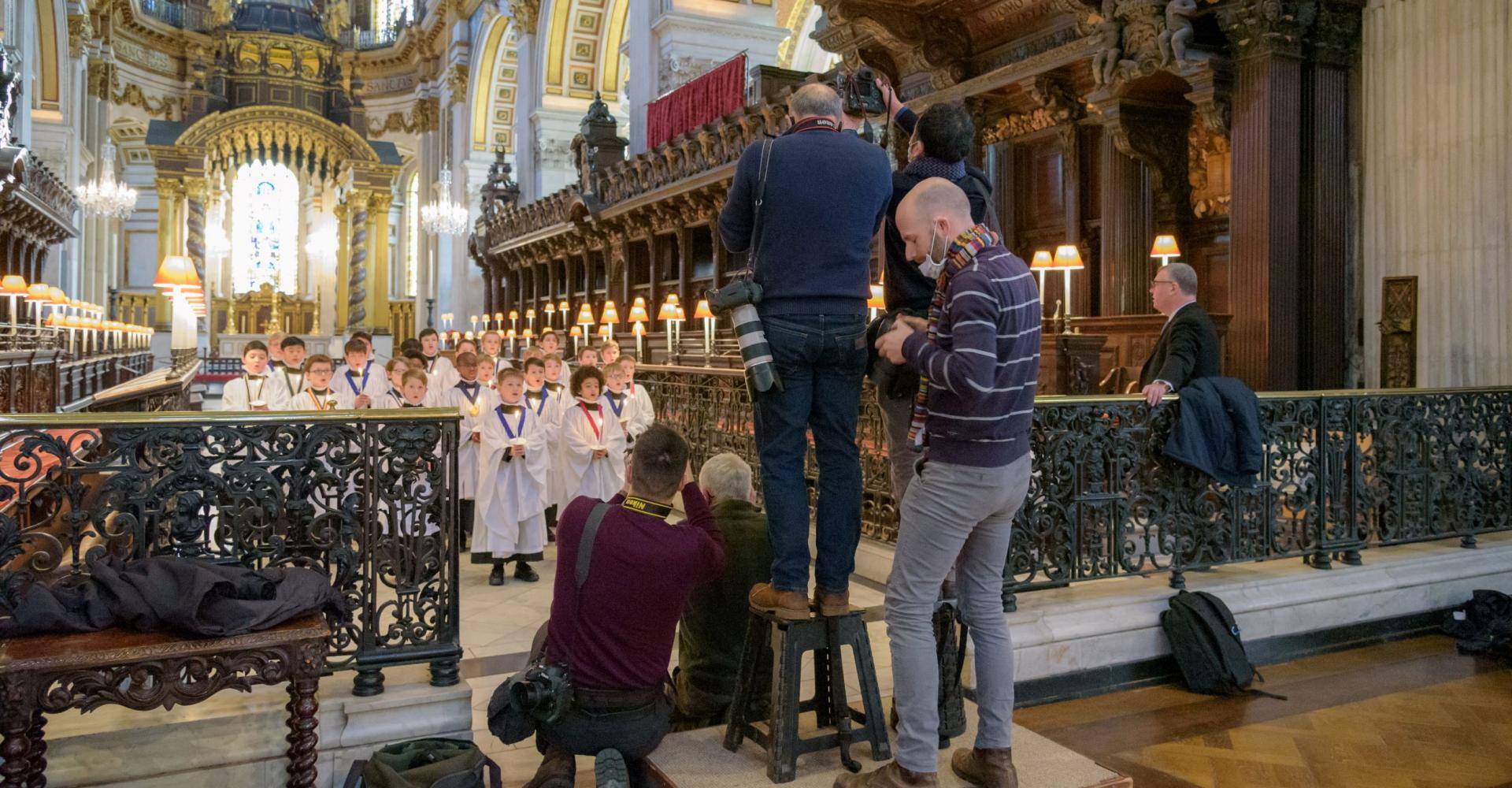 Press photographers take photos of the choristers during a media visit