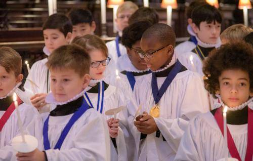 choristers boys sharing candle light christmas