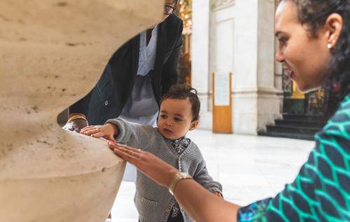 little boy touching cathedral stone