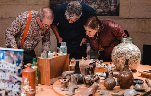 People looking at mudlarking finds.